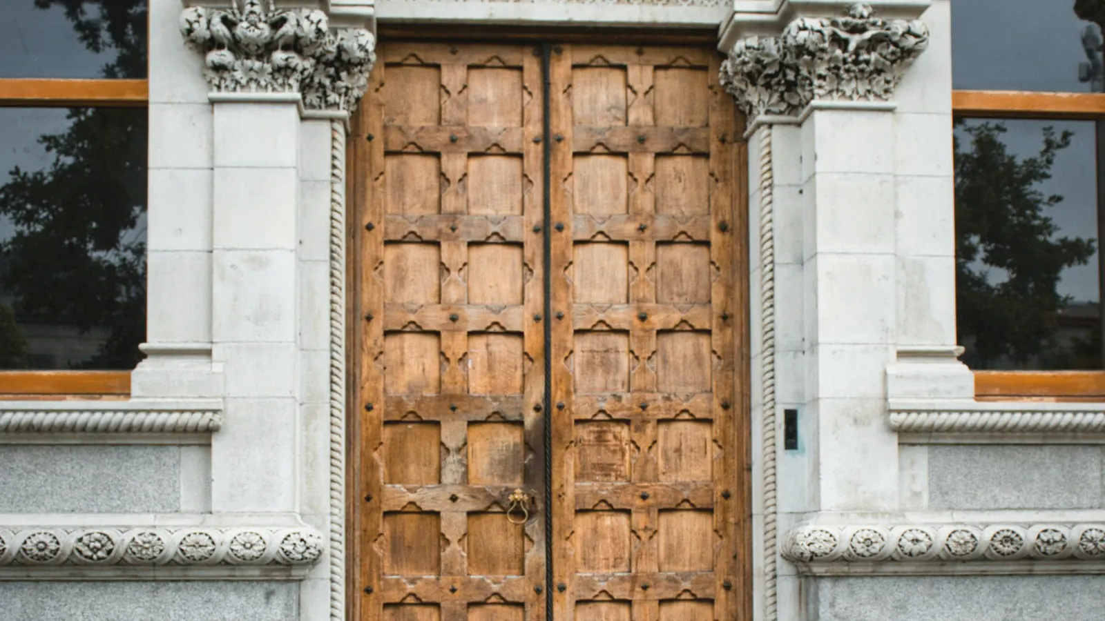 Ornate wooden double doors set in a carved stone arch.